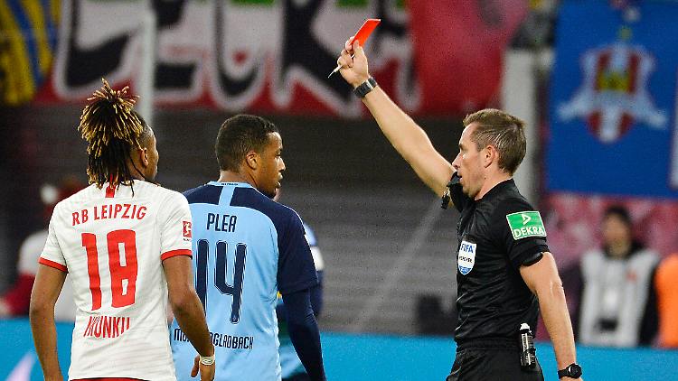 Ein Schiedsrichter zeigt dem Gladbacher Spieler Plea die Rote Karte, daneben Mukiele von RB Leipzig
