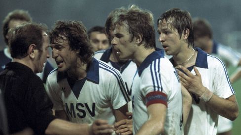 Historische Aufnahme: Spieler des MSV Duisburg bedrängen den Schiedsrichter, einer schreit ihn aus nächster Nähe an